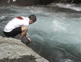 Julian fills his Camelbak water bottle from the icy mountain river